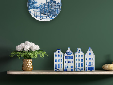 Delfts blauw bord met grachtenpanden en huisjes op de plank