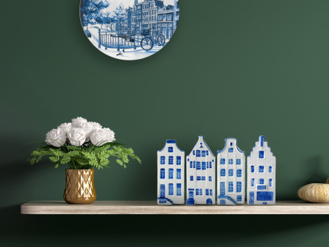 Delfts blauw bord met grachtenpanden en huisjes op de plank