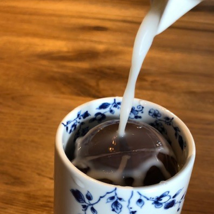 Melkchocolade maken met een chocolade bomb en warme melk in een Blauw Vouw cappuccinomok