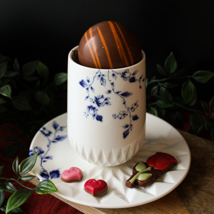 Chocolade bomb in warme melk in een blauw vouw cappuccino mok