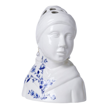 Een vaas in de vorm van het meisje met de Parel.  Bloemen kunnen in de openingen bovenop het hoofd worden gestoken.  Haar omslagdoek is gedecoreerd met Delfts blauwe bloemen.