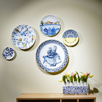 Het wandbord met Delftsblauwe bloemen en bosvogels hangt tussen 4 andere wandborden ter inspiratie